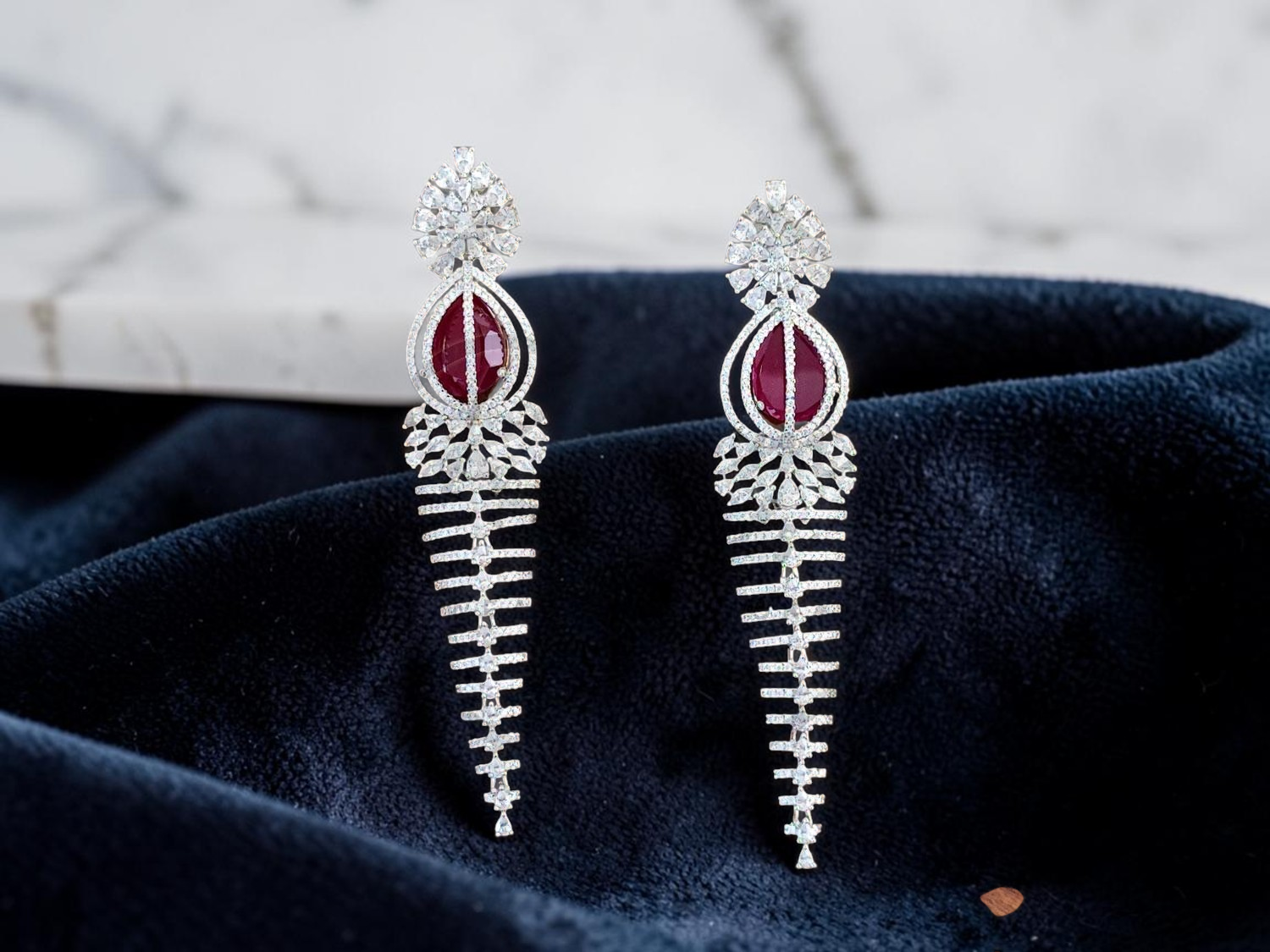 Elegant Rhodium-Plated Cascading Chandelier Earrings with Ruby-Red Centerpiece.