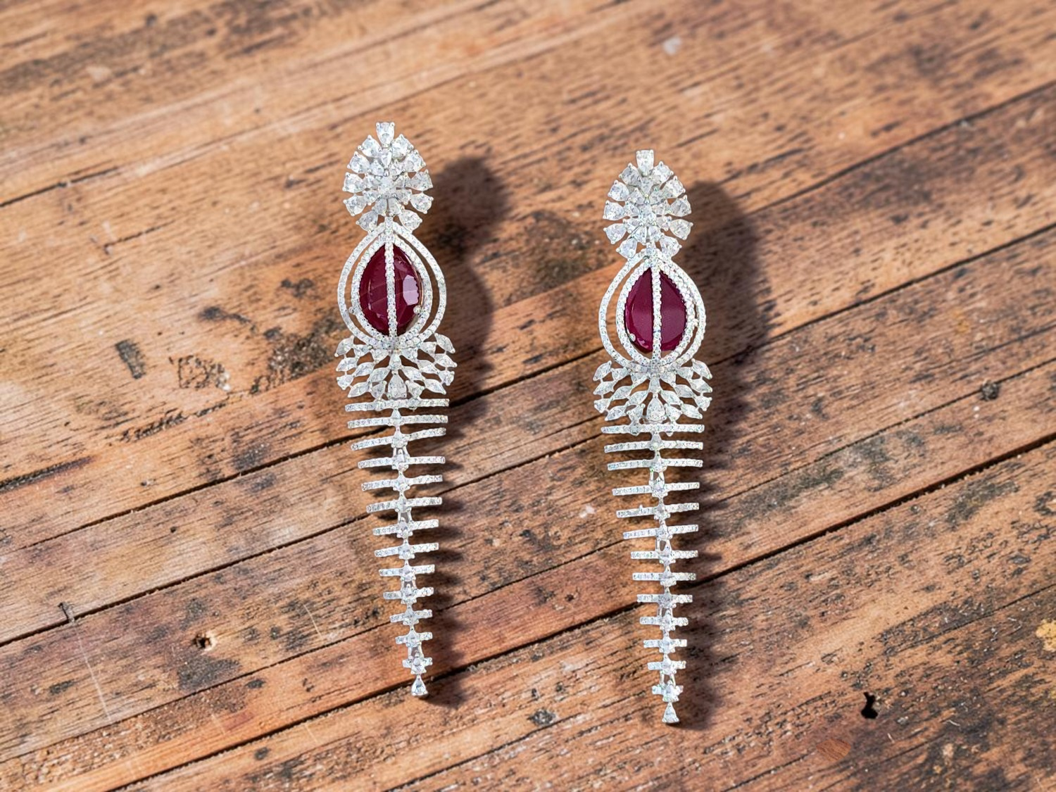 Elegant Rhodium-Plated Cascading Chandelier Earrings with Ruby-Red Centerpiece.