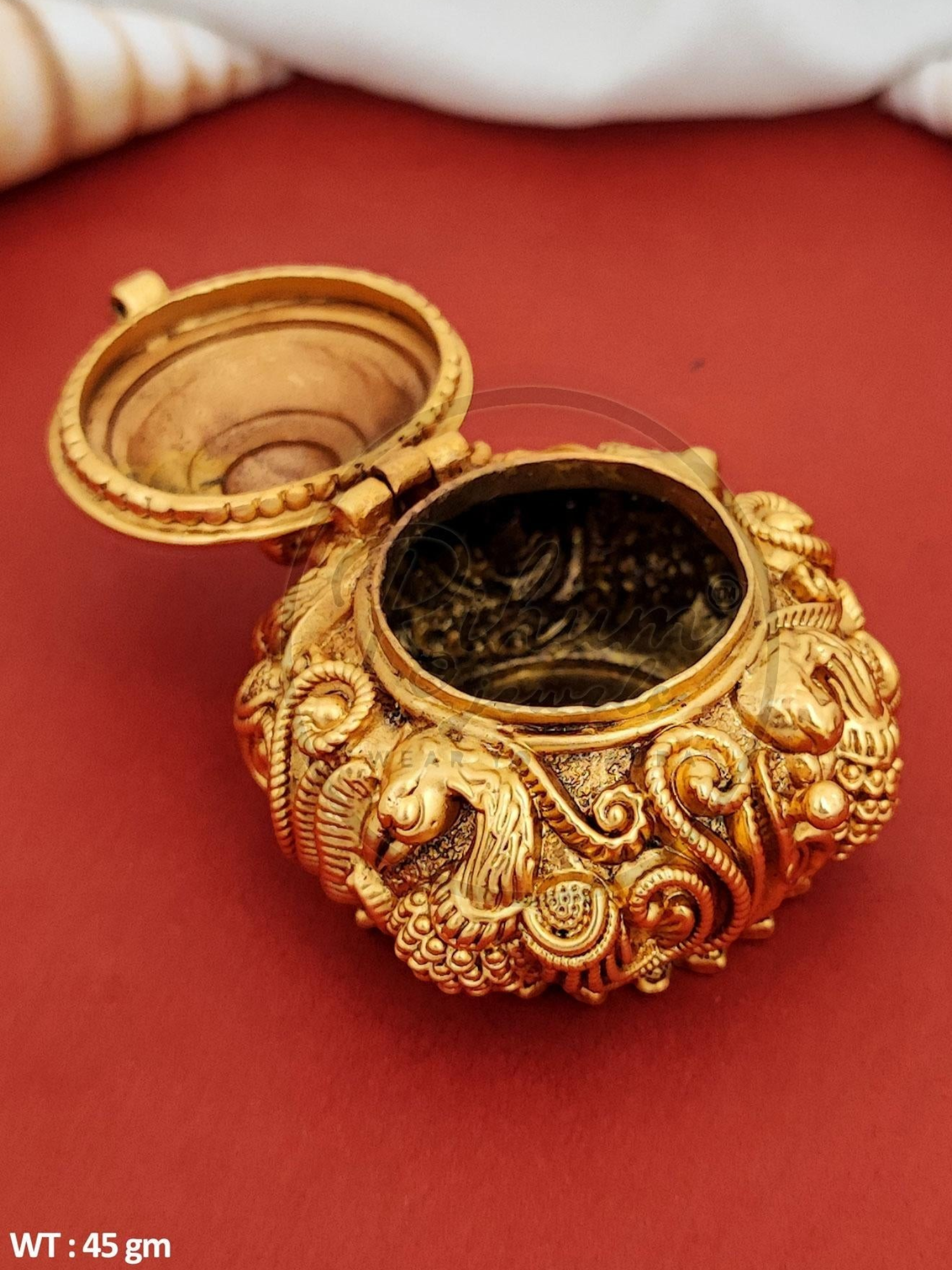 Rihum Jewels handcrafted gold-plated antique kumkum box with intricate peacock nakshi design and hinged lid.