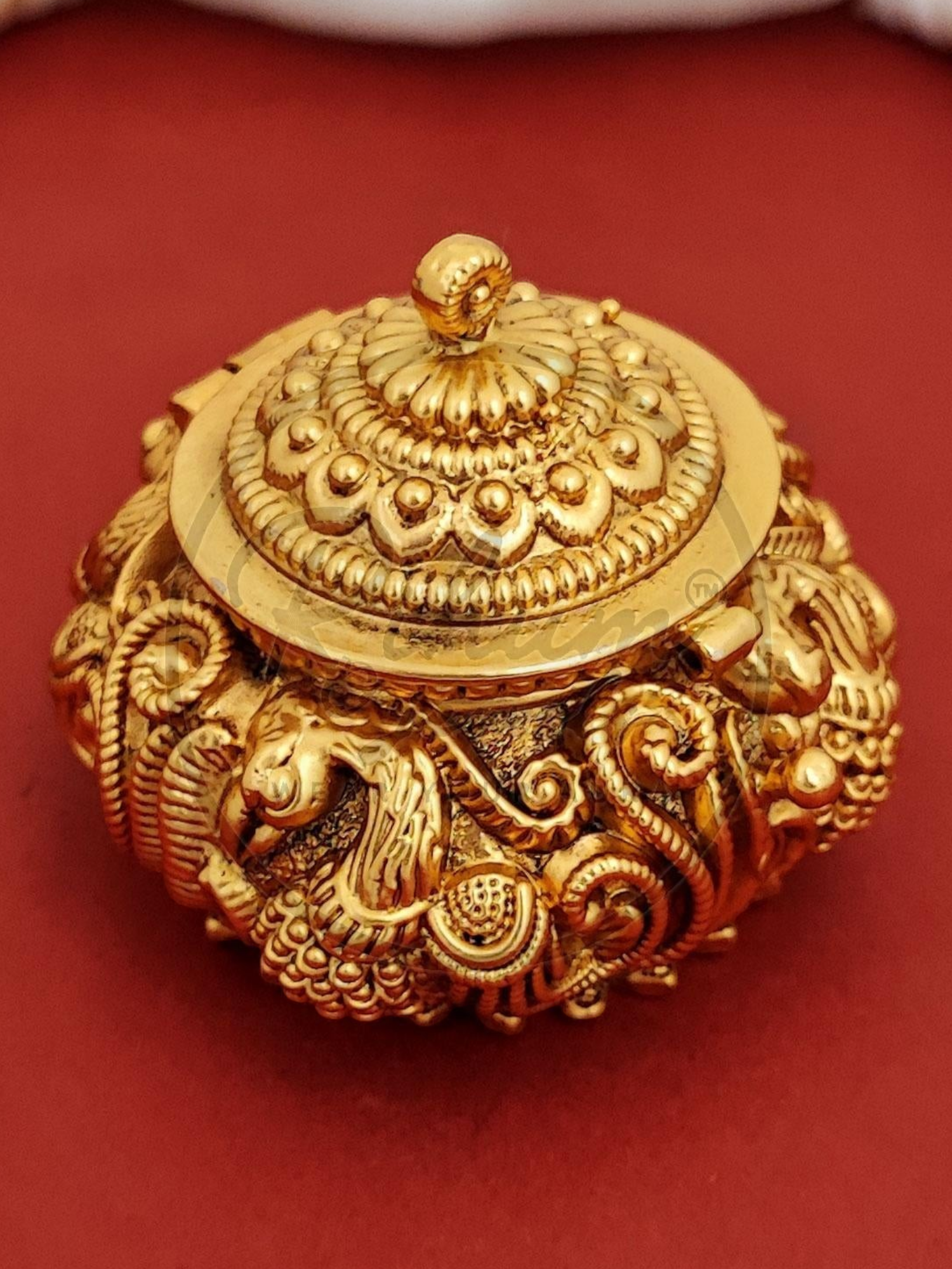 Rihum Jewels handcrafted gold-plated kumkum box with intricate peacock Nakshi engravings and antique Rajwadi finish.